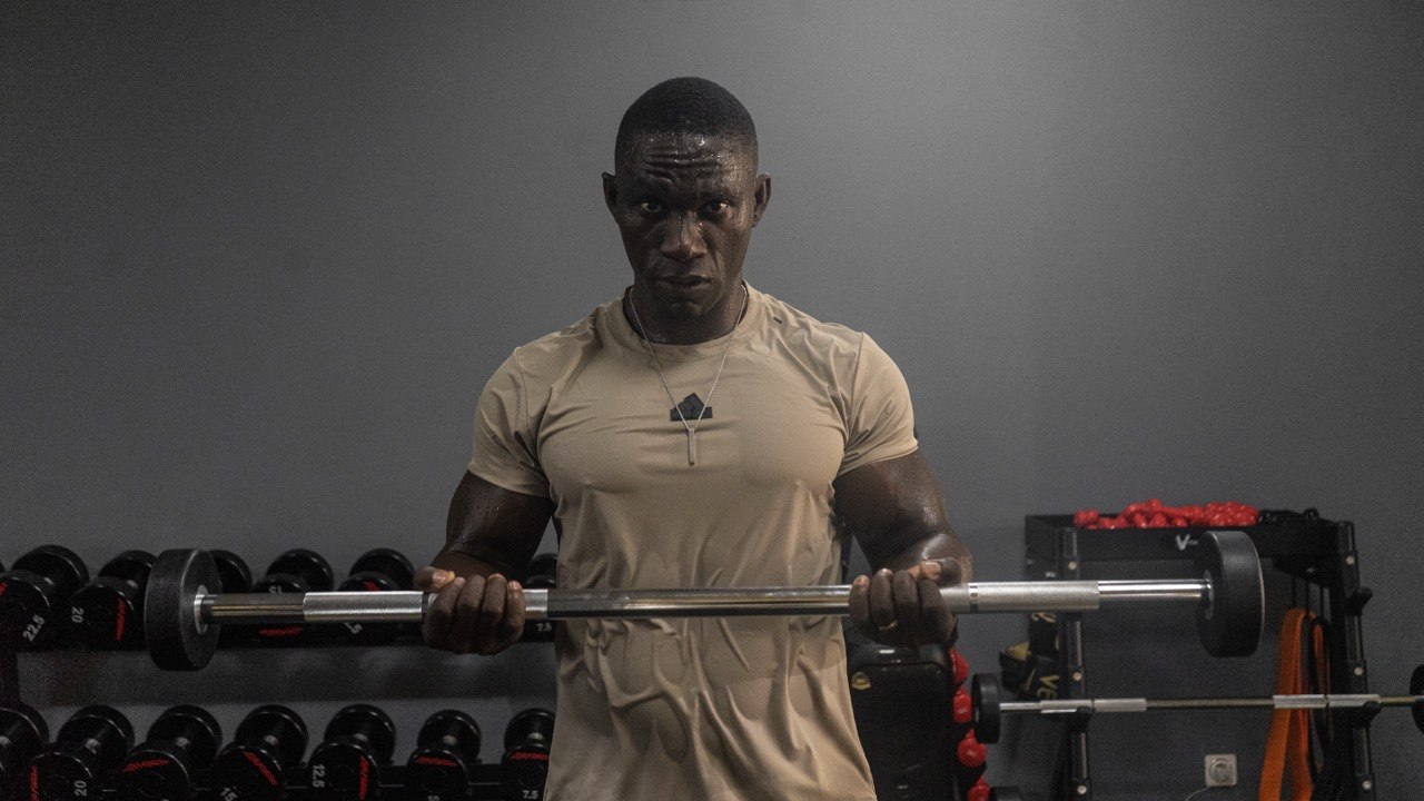Athlete in a dark industrial gym with yellow accents.