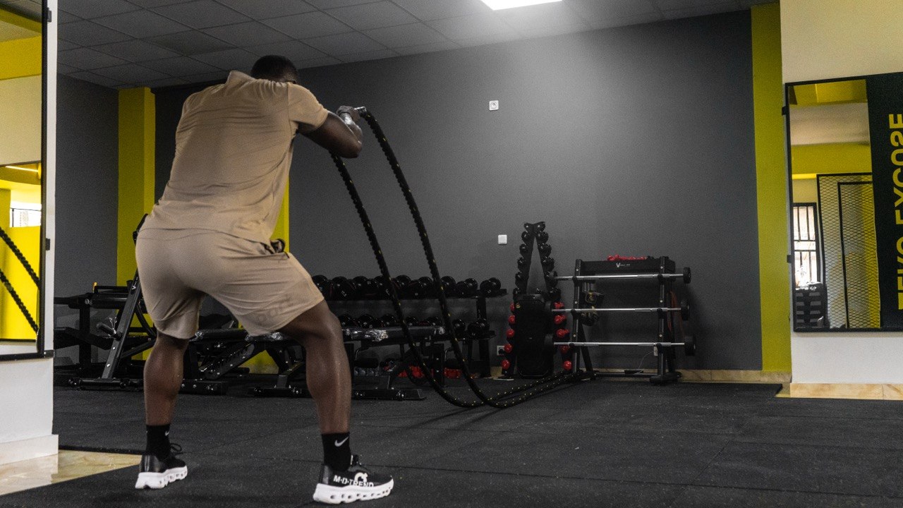 Group of athletes cross-training in a dark gym with yellow accents.